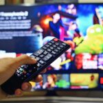 pessoa com controle remoto acessando a Netflix com a melhor VPN